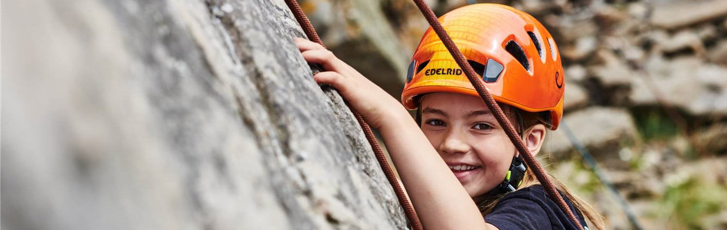 Young girl wearing a helmet while rock climbing